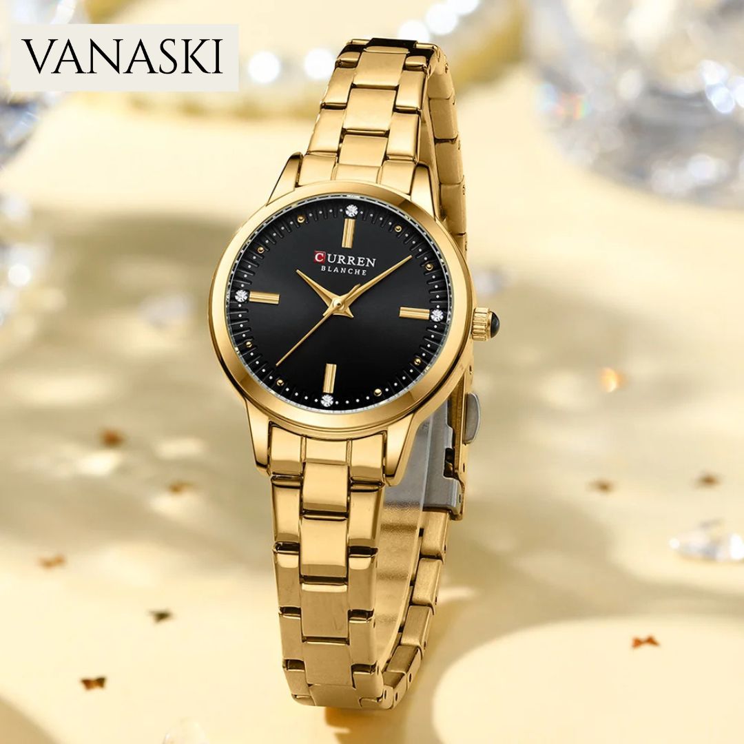 Gold wristwatch with black dial on a sparkling background, featuring the brand 'VANASKI'.