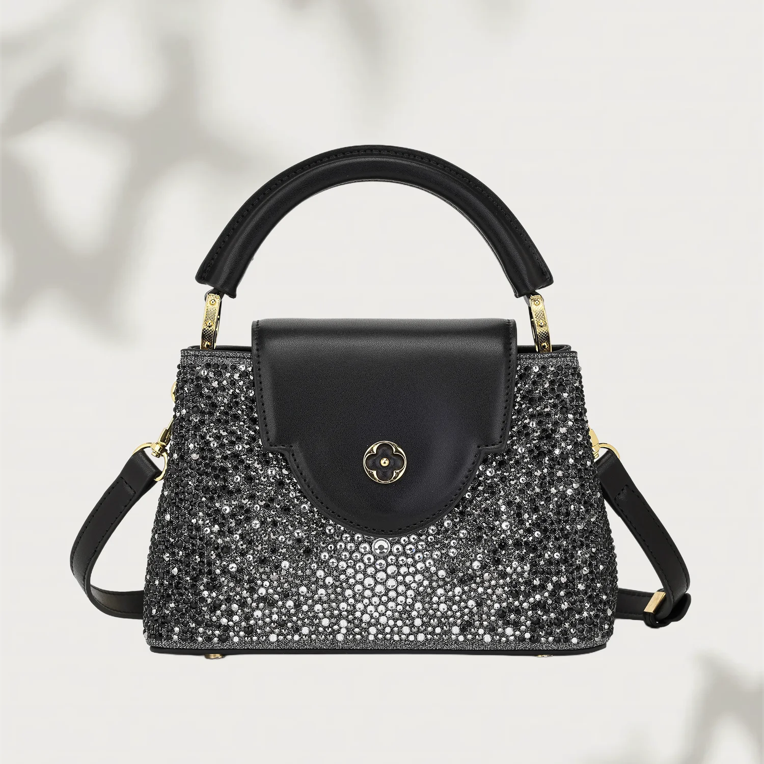Black handbag with sparkling silver embellishments on a light background