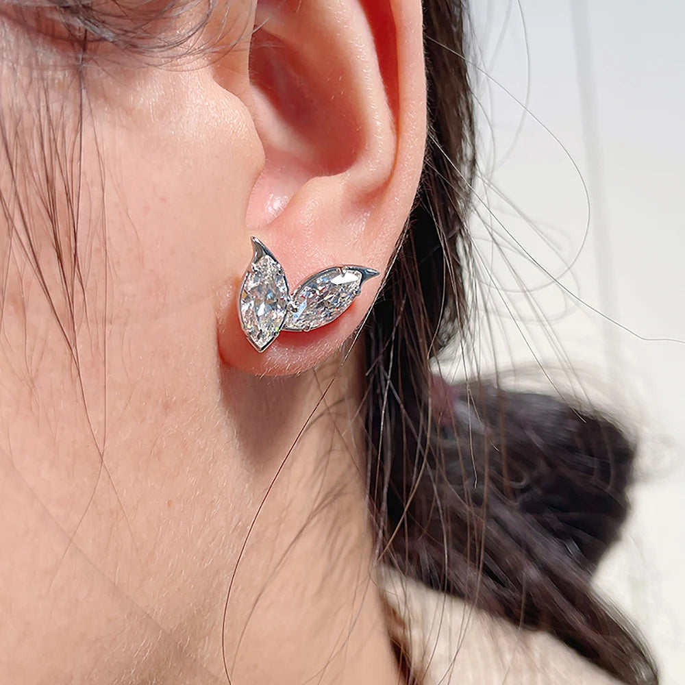 Close-up of an ear wearing a butterfly-shaped diamond earring.
