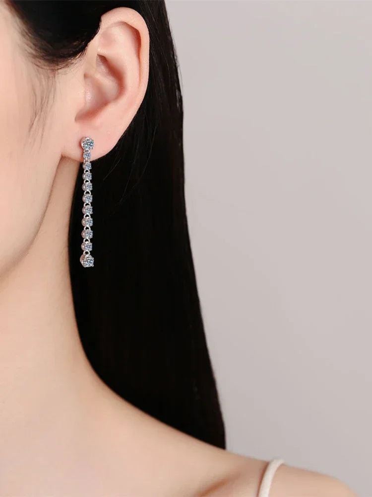 Close-up of a person wearing a silver earring with a gray background