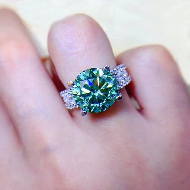 Green gemstone ring on a finger with a blurred background