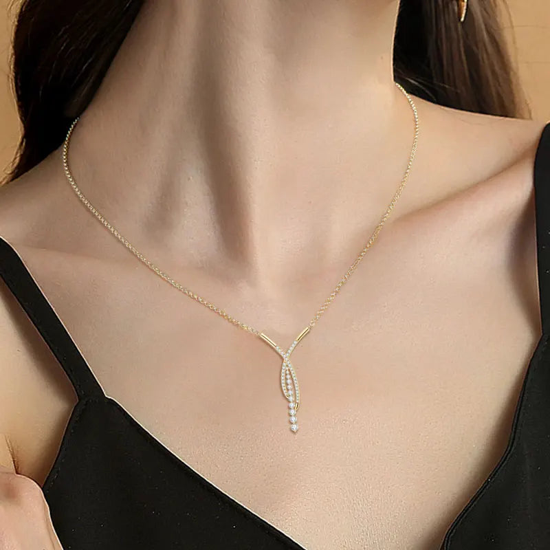 Gold necklace with a pendant on a model wearing a black top