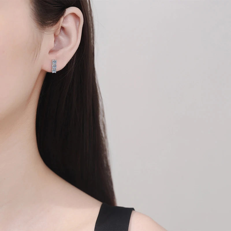 Close-up of an earring worn by a person with a neutral background