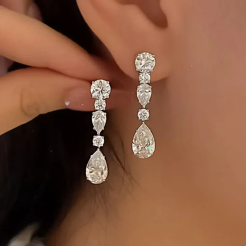 Close-up of a woman wearing a pair of diamond earrings.