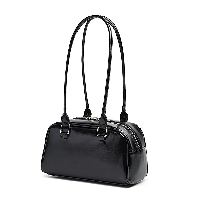 Black handbag with a glossy finish on a white background