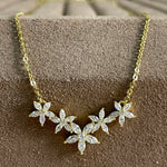 Gold necklace with diamond-like stones on a textured surface