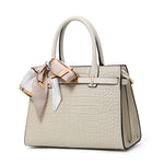 Beige handbag with a matching scarf on a white background