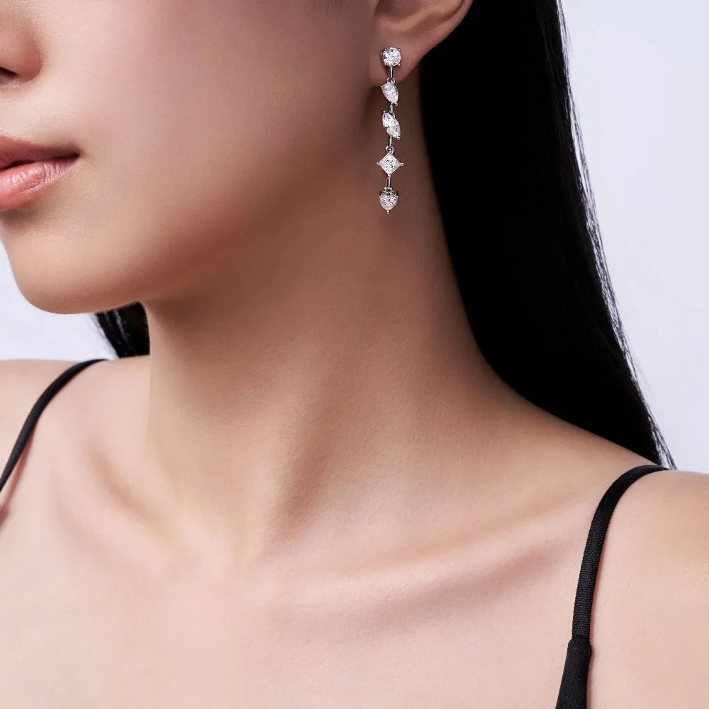 Close-up of a woman wearing elegant diamond earrings with a neutral background