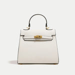 White handbag with gold hardware on a light gray background
