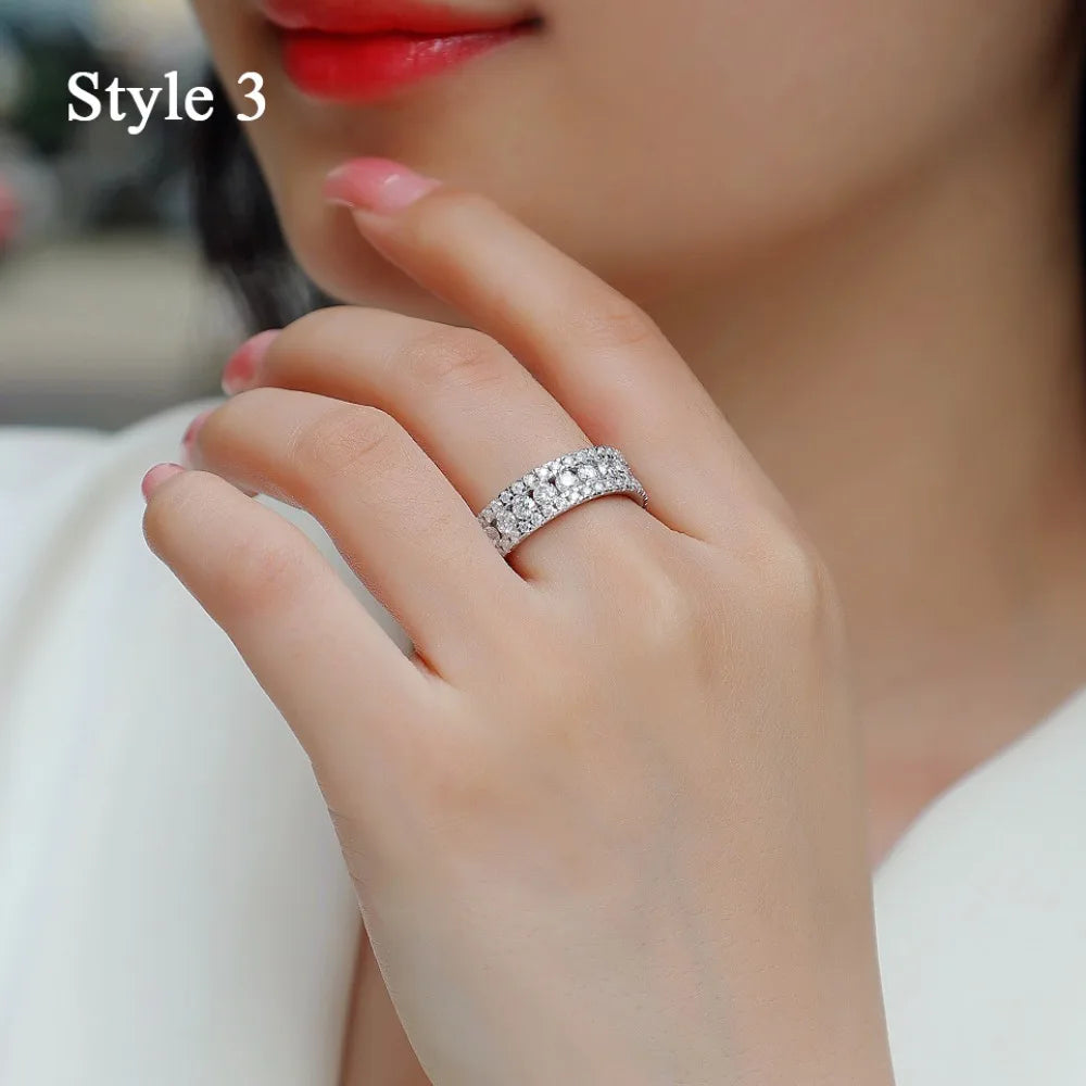 Close-up of a hand wearing a silver ring with gemstones, blurred background