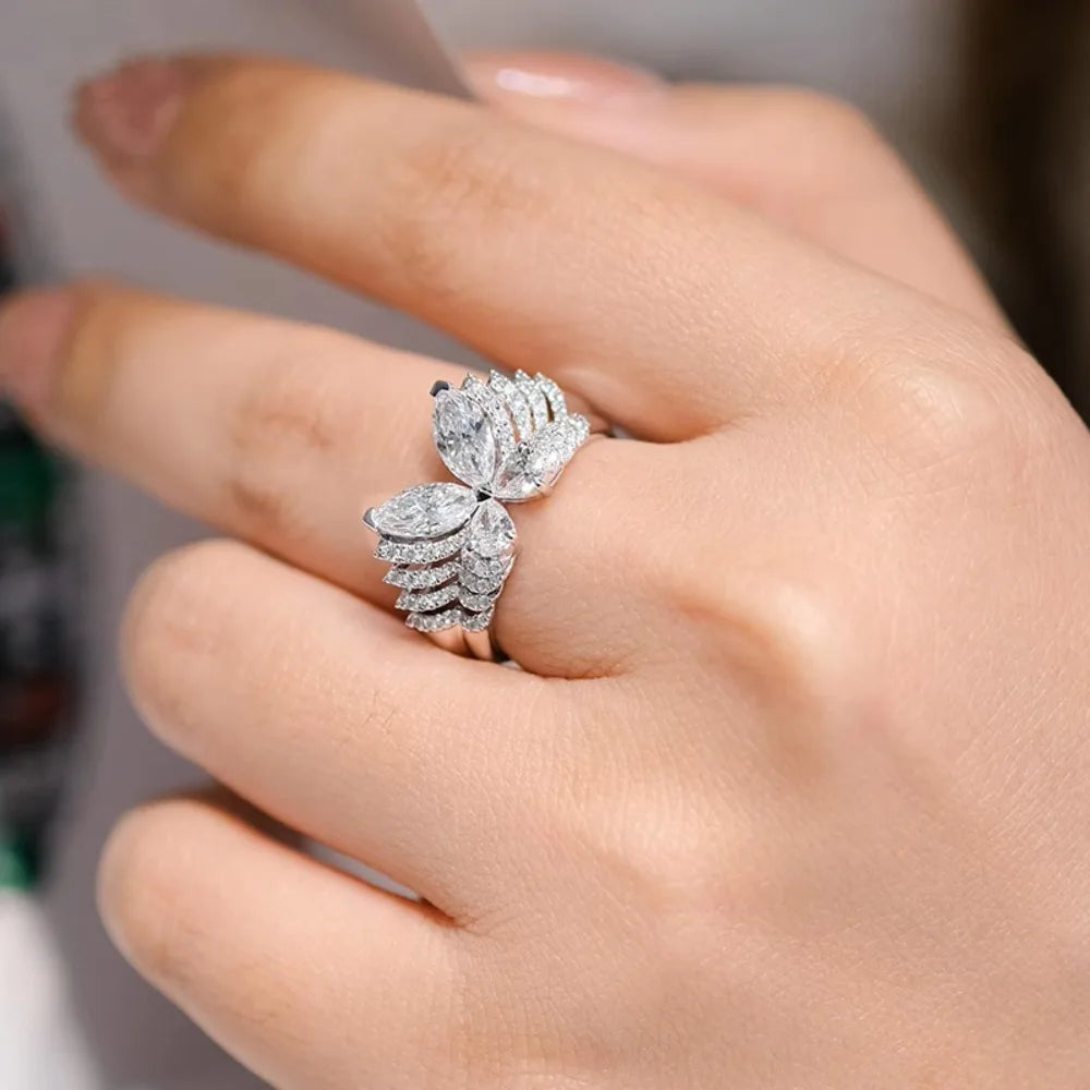 Silver ring with multiple diamonds on a hand against a neutral background