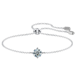 Silver bracelet with a heart-shaped diamond pendant on a white background