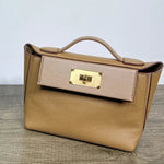 Beige handbag with a gold clasp on a wooden surface