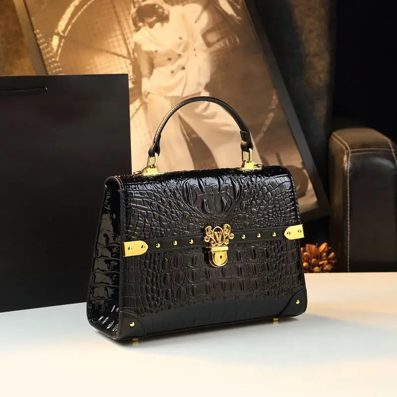 Black textured handbag with gold accents on a white surface