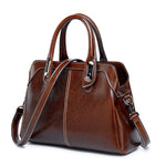 Brown leather handbag with a shoulder strap on a white background