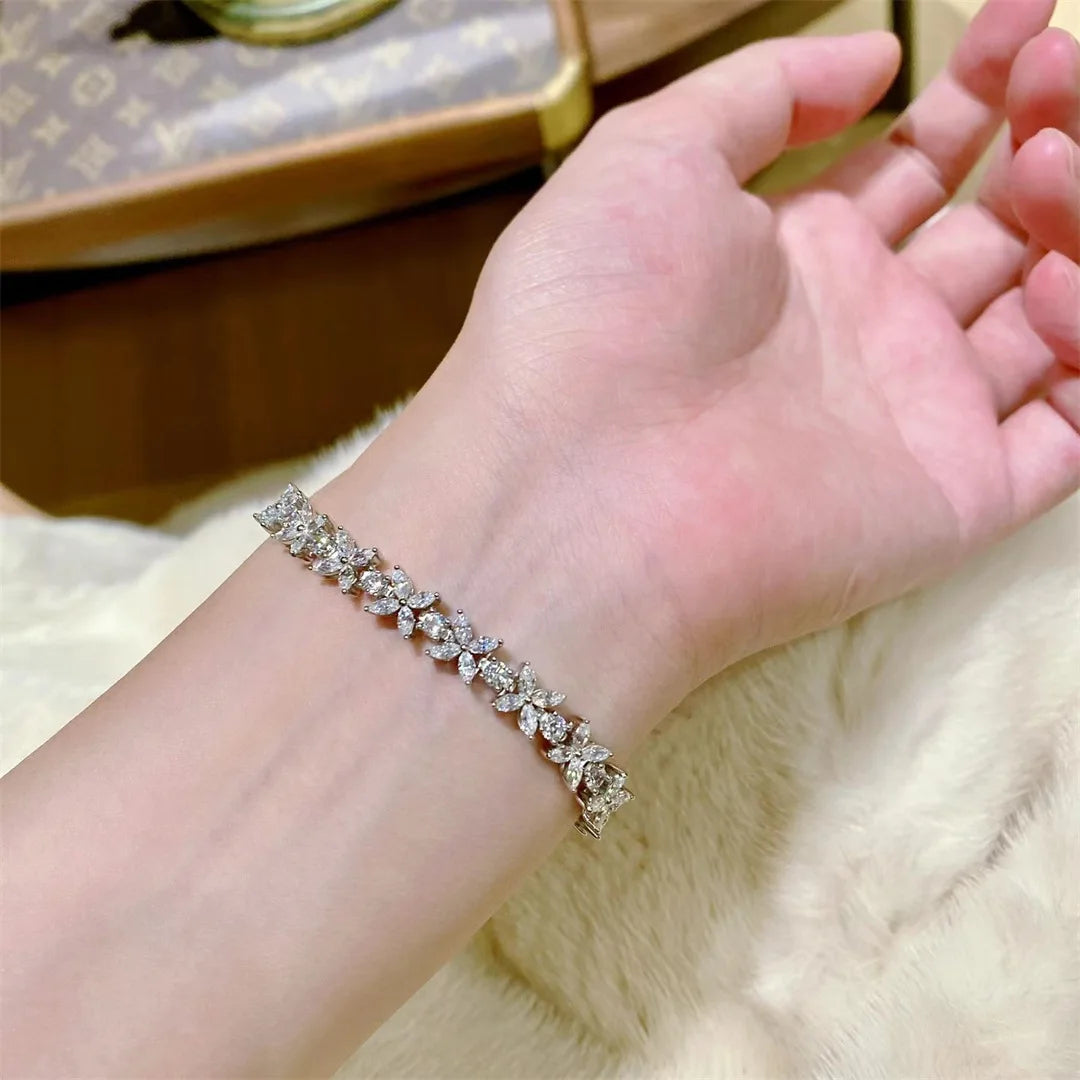 Hand wearing a diamond bracelet on a soft surface with a blurred background