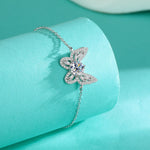 Butterfly-shaped silver bracelet on a turquoise background
