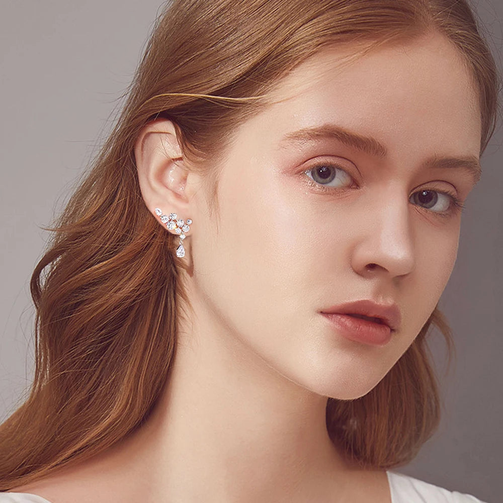 Close-up of a woman wearing a delicate earring with a neutral background