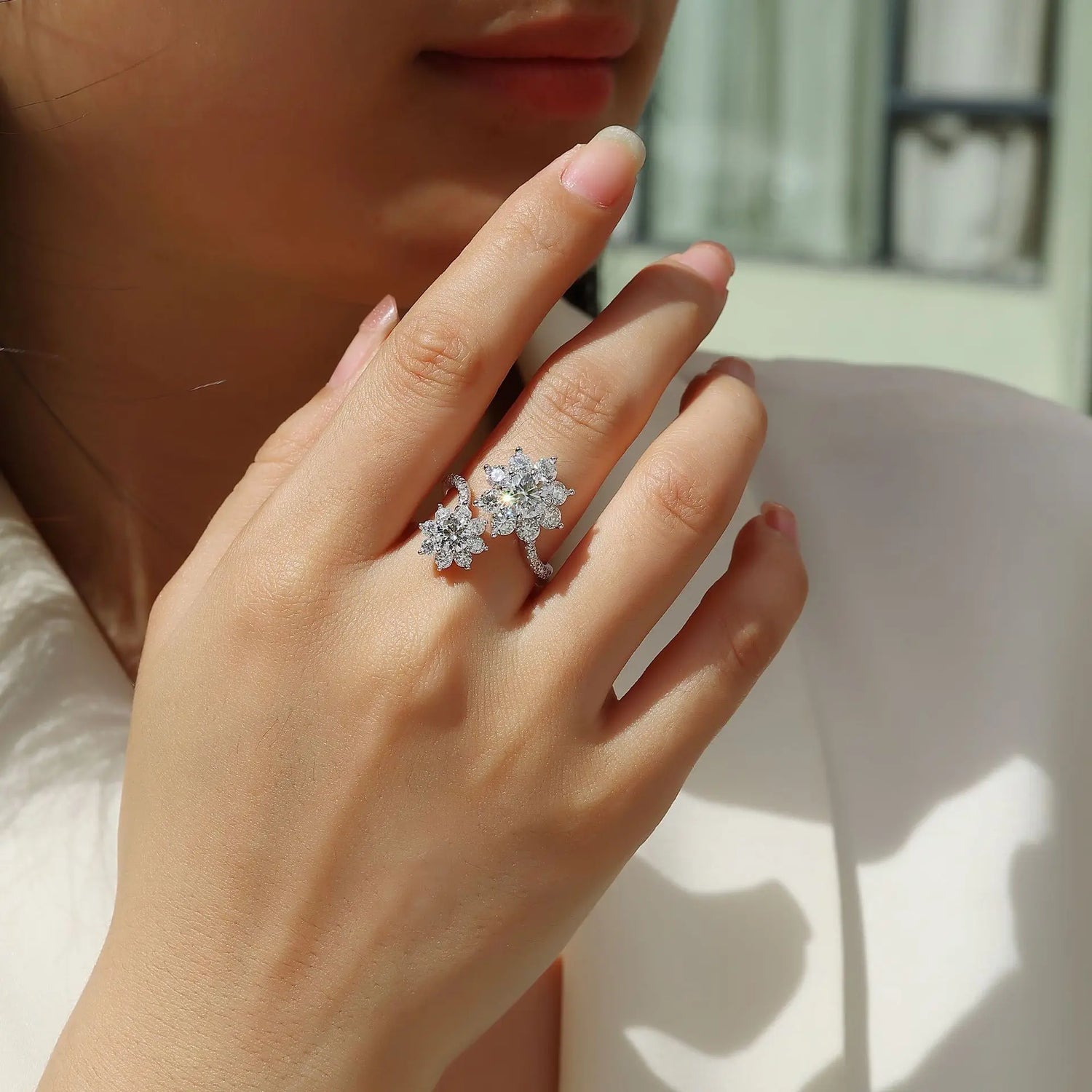 Close-up of a hand wearing a diamond ring with a blurred background