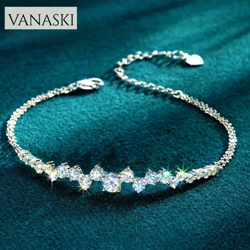Silver bracelet with clear stones on a teal fabric background, featuring the Vanaski brand.
