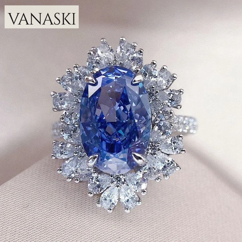 Ring with a blue gemstone and diamond-like stones on a beige background, featuring the Vanaski brand.