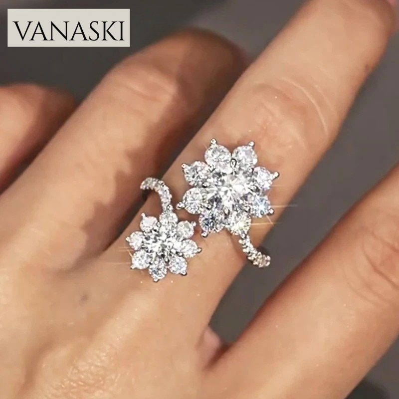 Silver floral ring on a finger with 'VANASKI' branding.