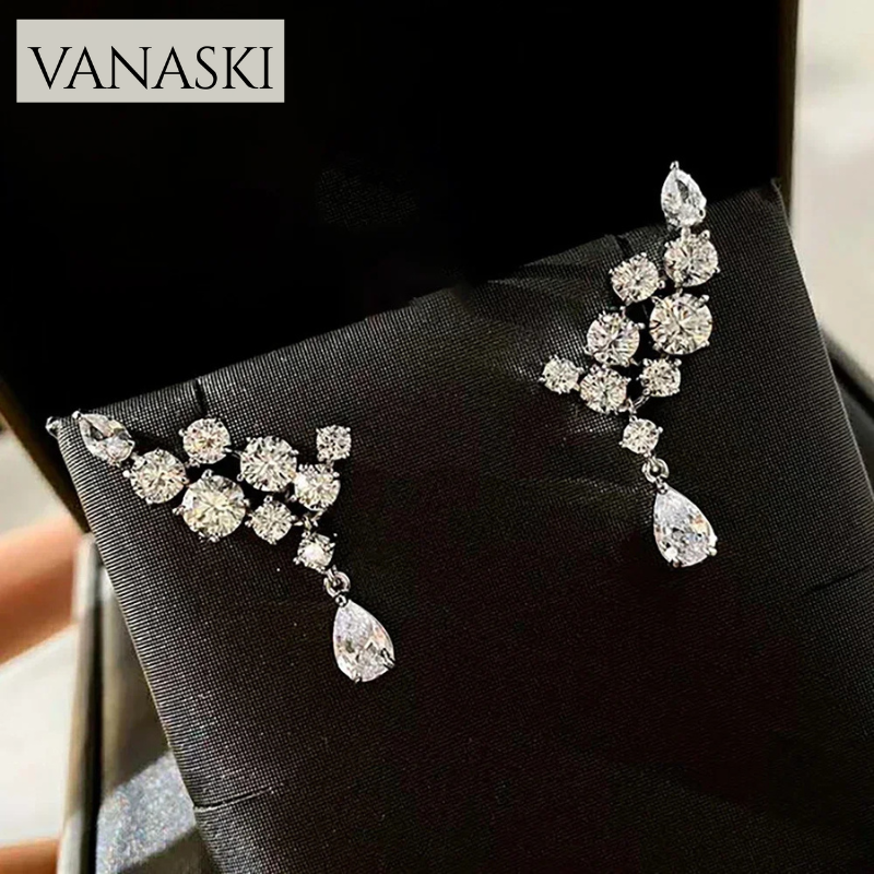 Pair of silver earrings with clear stones on a black box, featuring the Vanaski brand.