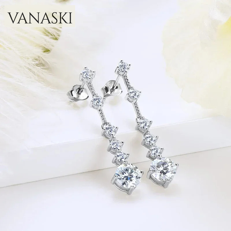Silver earrings with clear stones on a soft white background, featuring the brand 'VANASKI'.