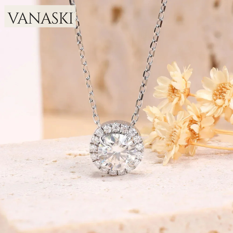 Silver necklace with a diamond pendant on a soft background with flowers.