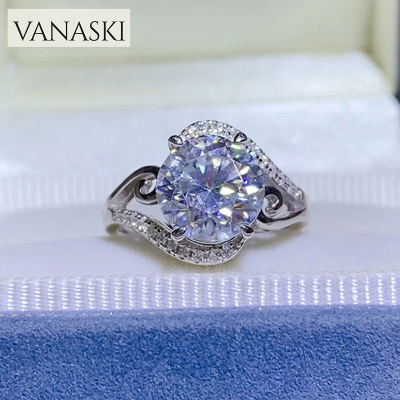 Silver ring with a large diamond on a blue cushion, branded 'VANASKI'.