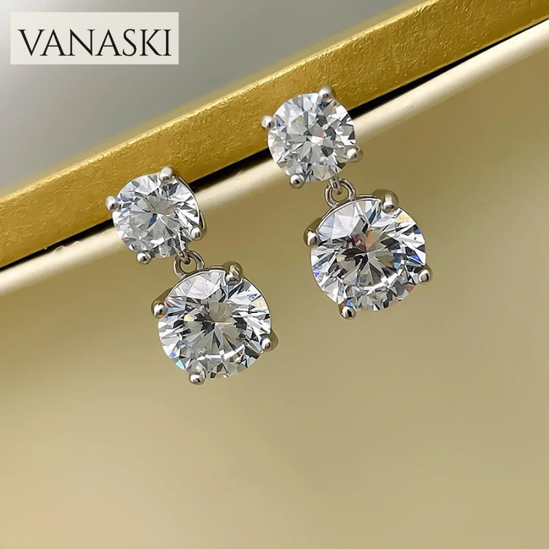 Diamond earrings with 'VANASKI' branding on a gold background