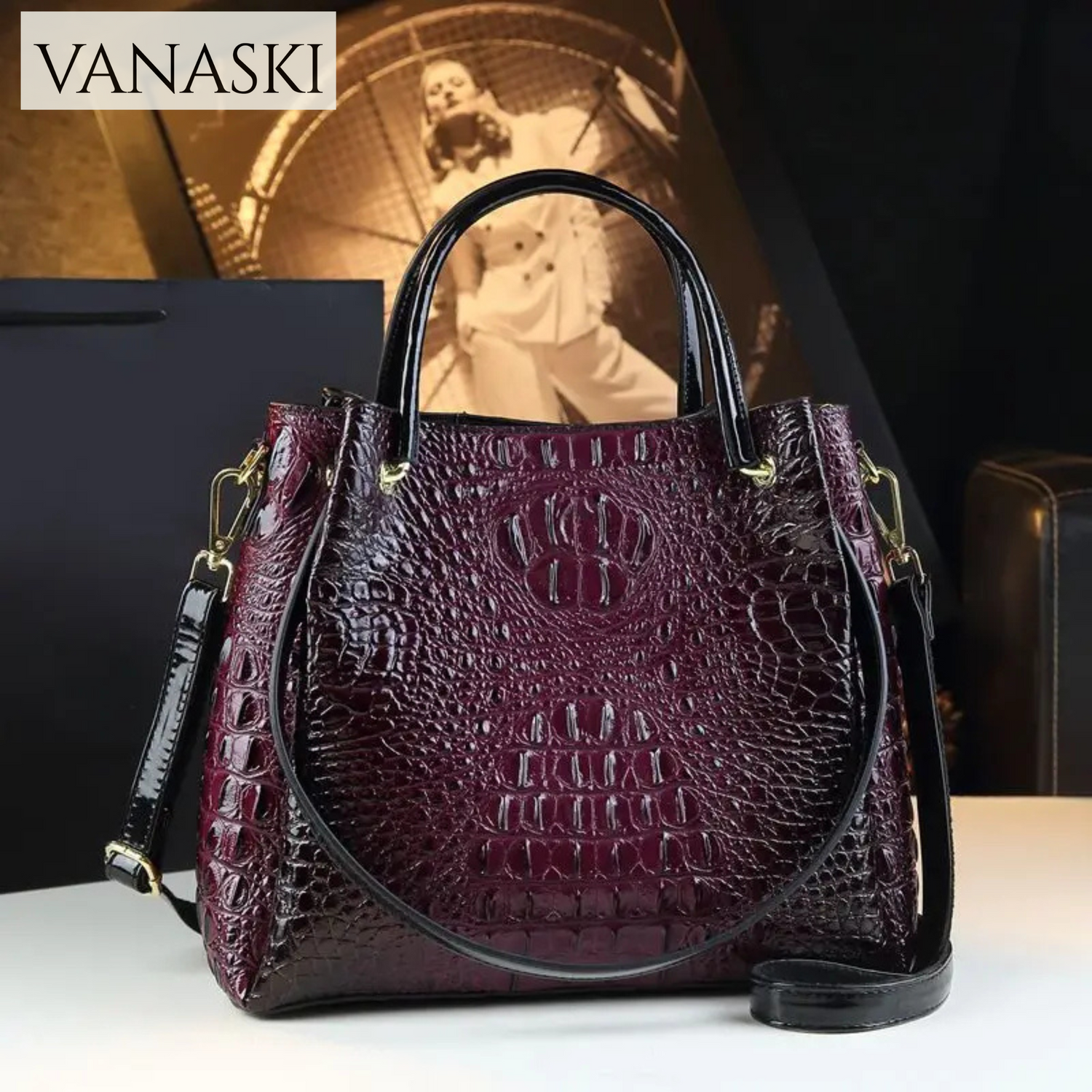 Purple textured handbag with gold accents on a white surface, Vanaski brand visible.