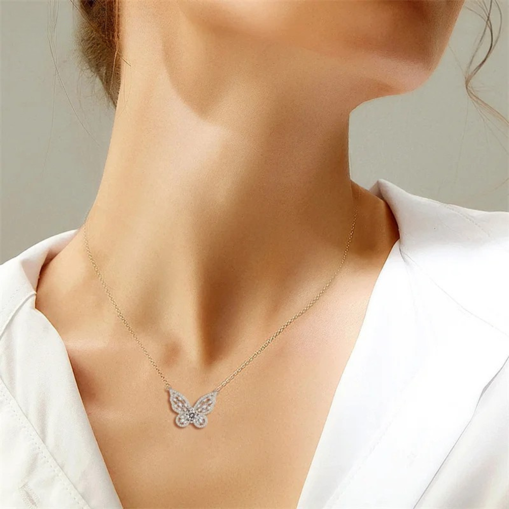 Butterfly necklace worn by a person with a neutral background