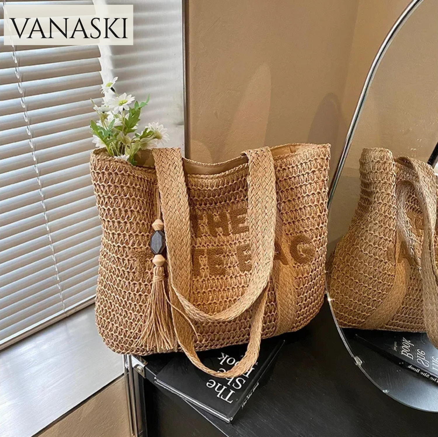 Woven handbag with tassel on a surface, branded 'VANASKI'.