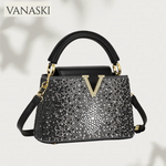Black handbag with sparkling details and gold accents on a light background, featuring the Vanaski brand.