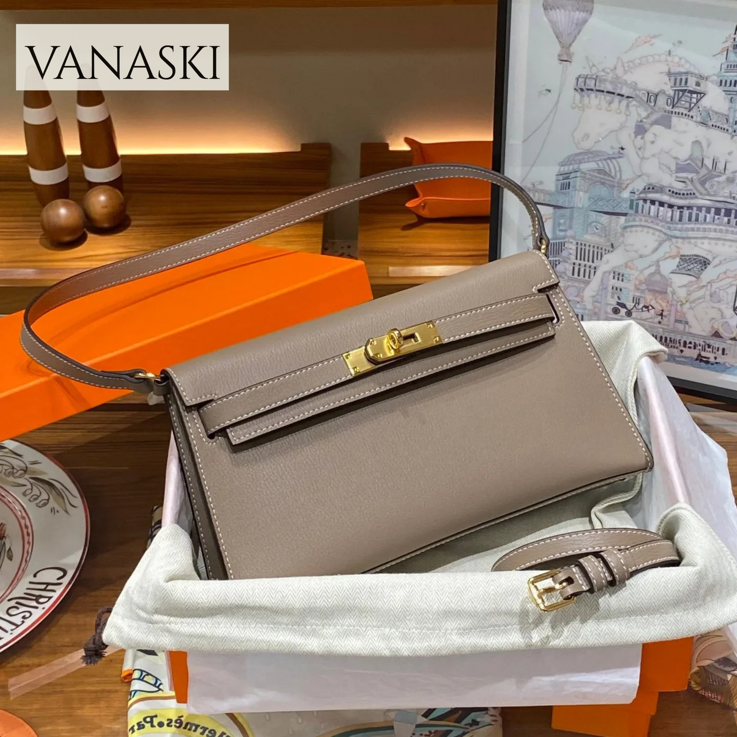 Beige handbag with gold hardware on a white surface, with Vanaski branding.