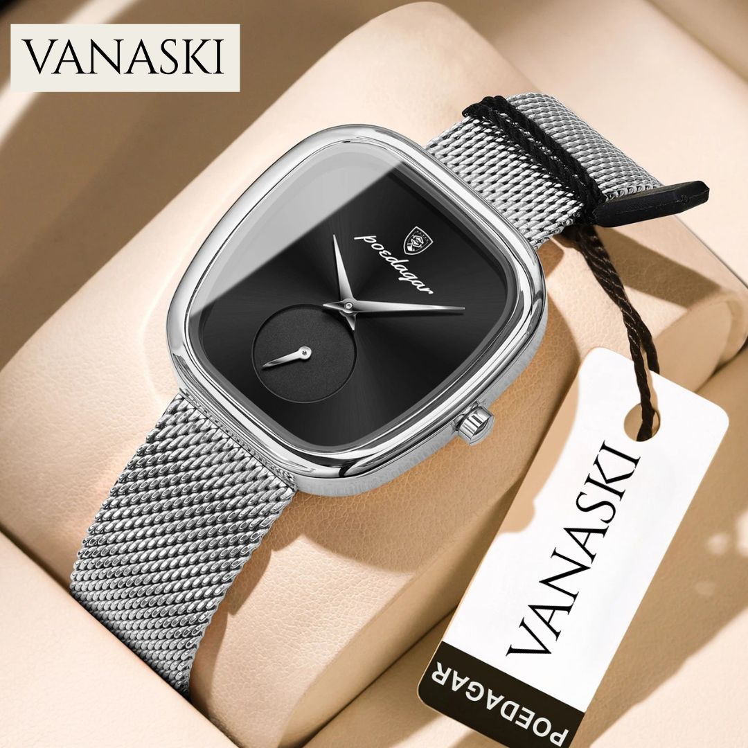 Silver watch with black face on a beige surface, featuring the VANASKI brand.