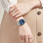 Hand wearing a smartwatch with a detailed face, against a neutral background