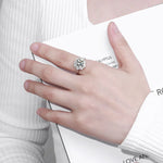 Hand wearing a diamond ring with a blurred background