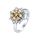 Silver ring with a large yellow gemstone and smaller clear stones on a white background