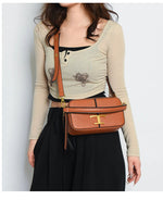 Person wearing a beige sweater and black skirt with a brown handbag on a white background