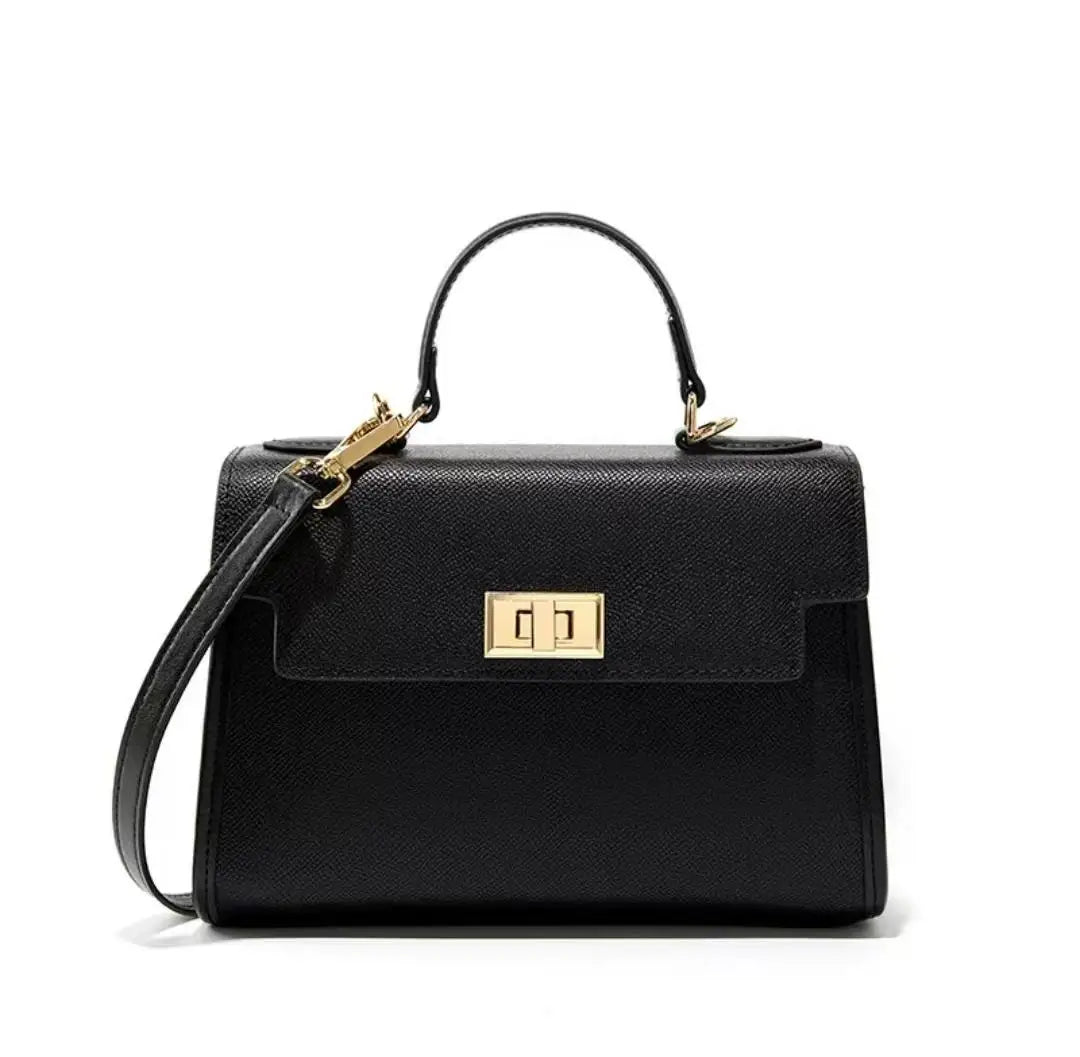 Black handbag with gold accents on a white background