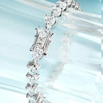 Silver bracelet with heart-shaped diamonds on a light blue background