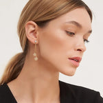 Close-up of a woman wearing a floral earring with a plain background