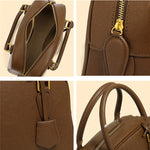 Brown handbag with gold zipper and handle on a beige background