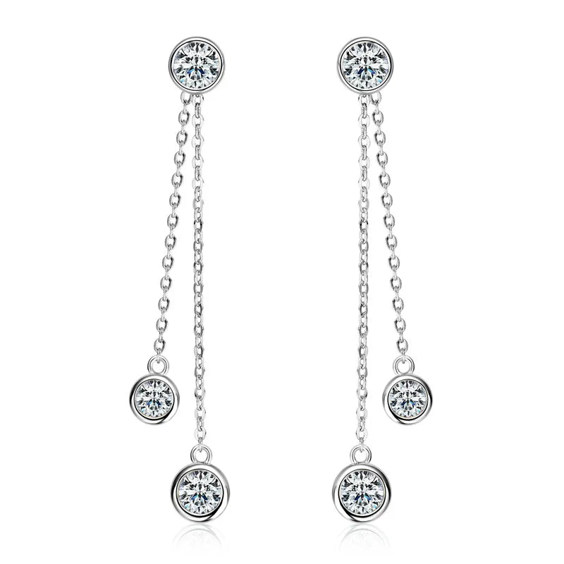 Pair of silver earrings with chain and round gemstones on a white background