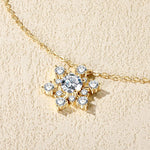 Gold necklace with a snowflake-shaped pendant on a beige background