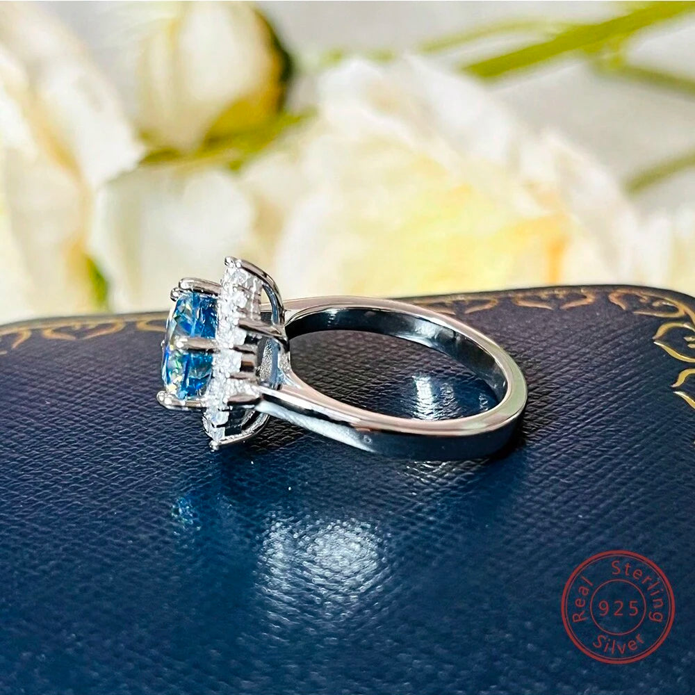 Silver ring with blue gemstones on a blue surface with floral background