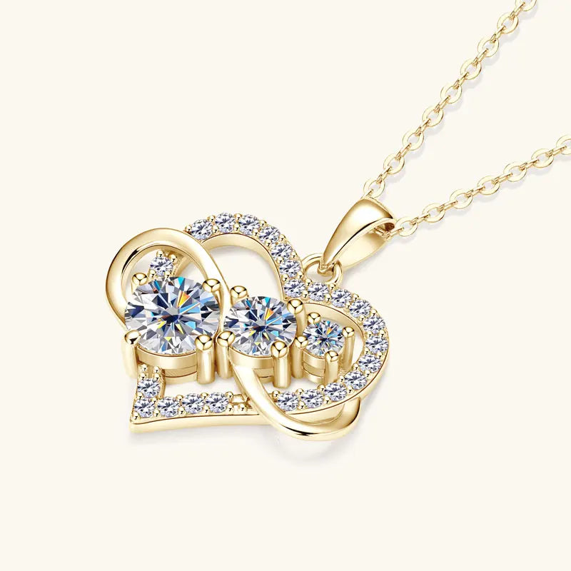 Gold necklace with a heart-shaped pendant featuring crystals on a white background