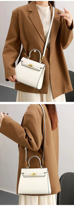 Person wearing a brown coat holding a white handbag with gold accents.